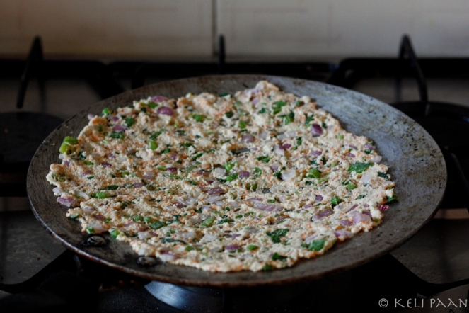 Spread out one portion evenly on the tava...